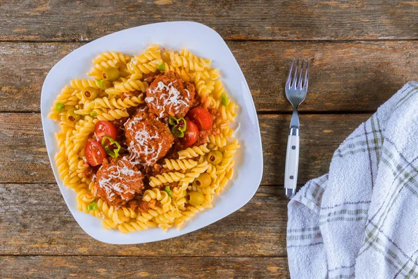 Rotini pasta met gehaktballetjes in tomatensaus en olijven in schaal. — Stockfoto