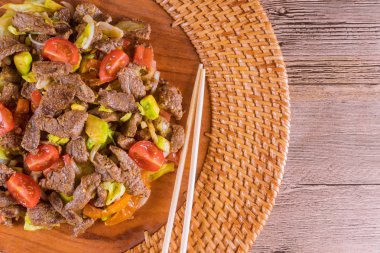 Kore yemeği. Kavrulmuş sığır eti, ahşap tabaktabaktabakta sebze ile servis