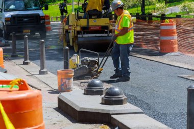 Yol silindir makinesi taze asfalt üzerinde çalışır