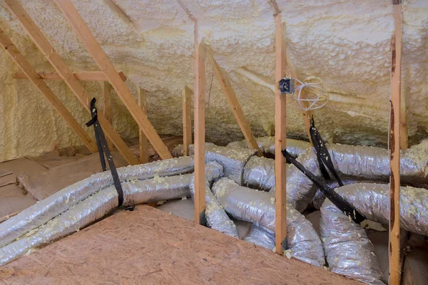 Casa tubos de ventilação de ar em material de isolamento de prata no sótão — Fotografia de Stock