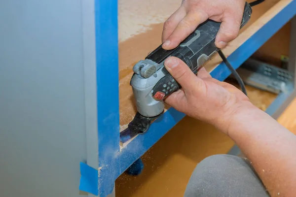 Entreprenör med oscillerande Multi funktionella skärande verktyg för Handyman cut hål i köksmöbler — Stockfoto