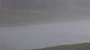 Şiddetli yağmur bir yerleşim bölgesinde bir fırtına yol sıçratıyor