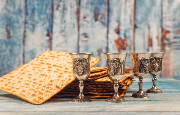 Passover fundo quatro copos de vinho e pão de férias judeu matzoh sobre tábua de madeira . — Fotografia de Stock