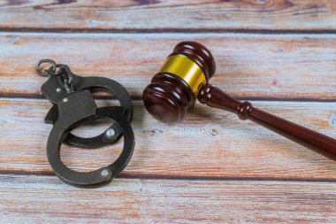 Hakim tokparat ve ahşap arka plan üzerinde kelepçe.