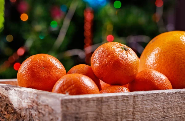 Klementinky nebo tangerinky v krabici na vánoční světla. — Stock fotografie