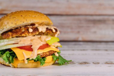 Marul, et, eritilmiş peynir soslu hamburger.