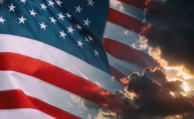 Amerikan bayrağı bulutlu gökyüzünde sallayarak ve ufukta parlak gündoğumu.