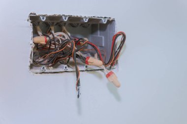 Apartmandaki alçı duvarlar için alçıpan alçıpan monte edilmiş elektrik telleri ve konektörlü bitmemiş elektrik şebekesi prizi soketi yapım aşamasındadır