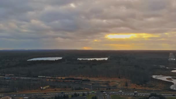 Вид с воздуха на жилые дома и придорожные районы во время осеннего захода солнца — стоковое видео