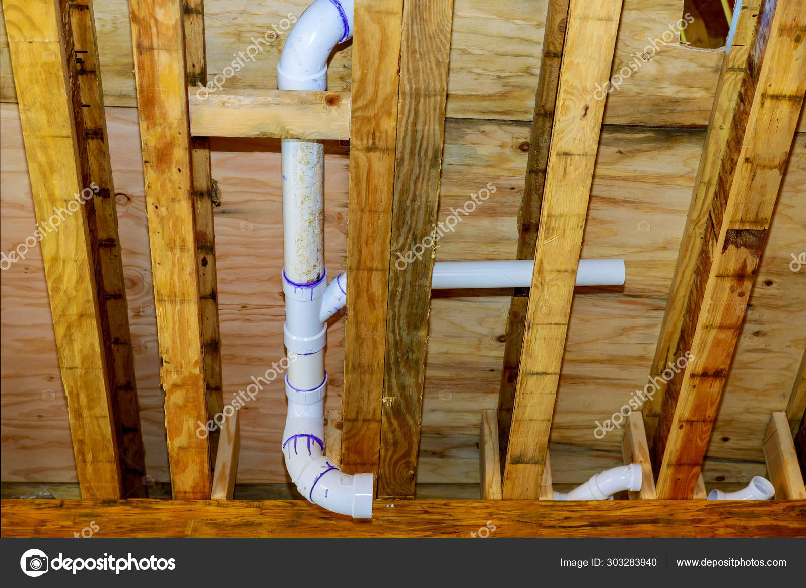 New home under construction plumbing drain pipes inside a house frame