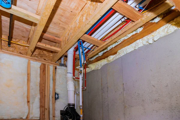 Nova casa em construção encanamento tubos de PVC dentro de uma casa de enquadramento com vista para o porão — Fotografia de Stock
