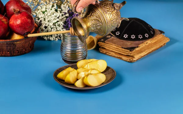 Una mano femenina toma una con miel para la rebanada de manzana y la fiesta de granada de Rosh Ha Shana — Foto de Stock
