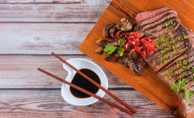 Kesme tahtası üzerinde mantar ile Dilimlenmiş ızgara sığır eti.