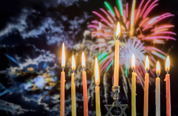 Hanukkah menorah con velas, colorido fondo cielo fuegos artificiales — Foto de Stock