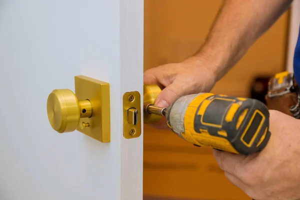 Instalación con cerradura en la hoja de la puerta mediante un destornillador de taladro, para sujetar tornillos —  Fotos de Stock