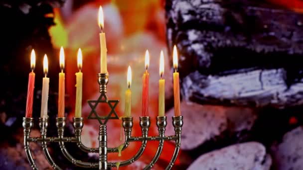 Festa ebraica Hanukkah con menorah candele tradizionali accese, fuoco brucia in un camino carboni ardenti — Video Stock