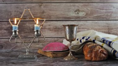 Tahta bir masa mumlar ve şarap fincan üzerinde challah ekmek ile Şabat.