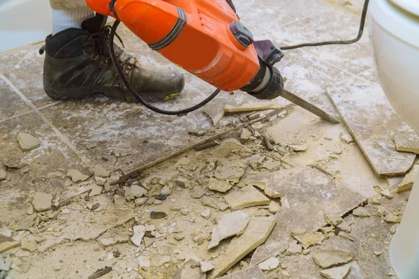 Demolition of old tiles with jackhammer. Renovation of old floor. — Stock Photo, Image