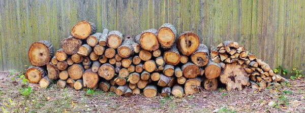 Stack of birch firewood near the fence