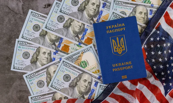 Украинский паспорт под флагом США со стодолларовыми векселями — стоковое фото