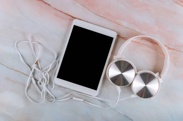 Moderne Kopfhörer und Tablet auf Marmortisch. — Stockfoto