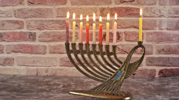 Menorah with candles for Hanukkah against defocused lights — Stock Video