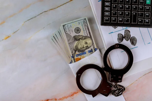 Manette su una serie di file di impronte digitali, banconote in dollari americani su calcolatrice con tassa penale finanziaria — Foto Stock