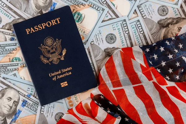 Patriotic american passport on top of a pile of one hundred US banknote currencies on American flag — Stock Photo, Image