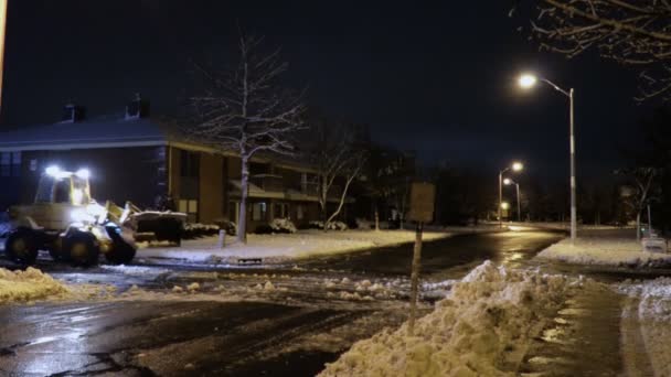 Noite a limpeza de trator de neve com bulldozer depois da queda de neve. O graduador rakes a neve na nevasca — Vídeo de Stock