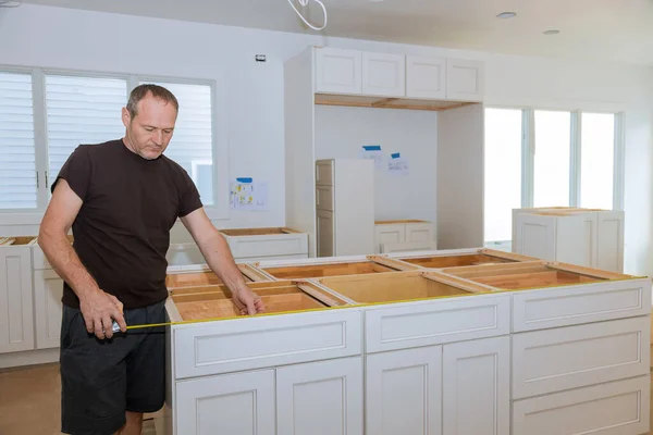 Man using tape measure for measuring size in modern kitchen for home improvement. — ストック写真