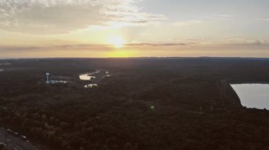 Mavi göller ve yeşil ormanlardan oluşan muhteşem bir günbatımı manzarası.