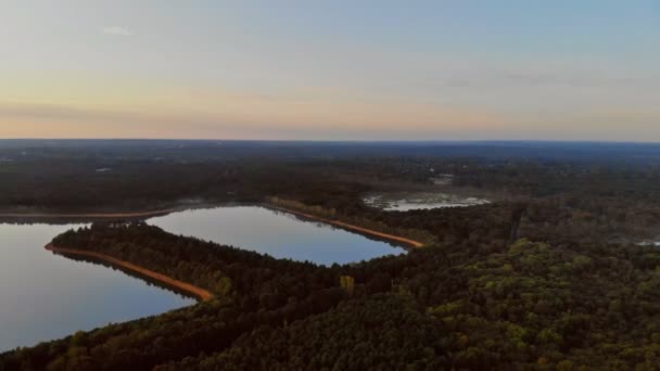 Un strălucitor la apus de soare peste lac cu pădure — Videoclip de stoc