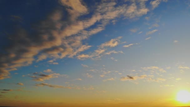 Cielo azul y naranja luz del sol a través de las nubes en el cielo — Vídeo de stock