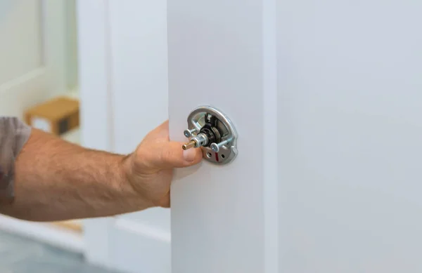Carpintero macho fijando cerradura en puerta con hogar — Foto de Stock
