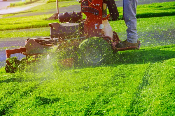 芝生の芝刈り機を使用して芝生の芝刈り機の男と芝生の芝刈り機で庭師の草刈り機 — ストック写真
