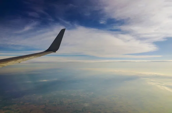 雲の上を飛ぶ飛行機青空を背景に翼 — ストック写真