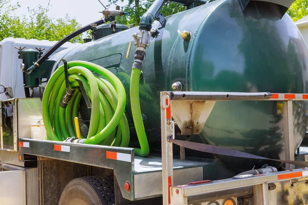 Vacuum waste truck on the cleaning process portable bio toilet cabins at the construction