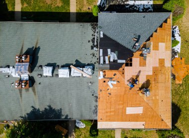 Yeni çatı kiremitleri takılmış bir apartman dairesinin çatı tamircisinin havadan görünüşü