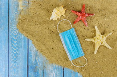 Coronavirus COVID-19 salgını sırasında kumsalda tıbbi koruyucu maske..