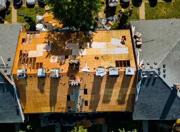 家の屋根を修理する家の屋根の上にある帯状のものに代わる労働者 — ストック写真