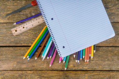 Masada renkli kalem, cetvel, yapıştırıcı ve makas çeşitleri var.