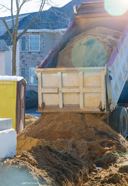 トラックは建設のために地面に土を注いでいますランドマークは建設中です — ストック写真