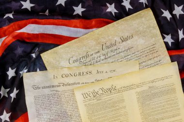 Closeup of a replica of U.S. document of American constitution We the people with USA Flag. clipart