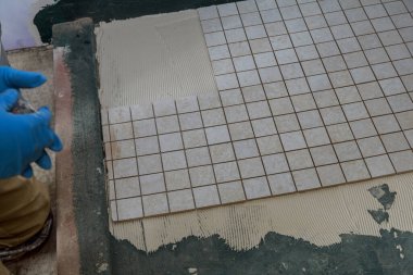 Fayans döşeme alçı onarım işi, bir adamın elinde mala.