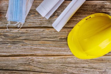 Covid-19 Coronavirus önleme yüz maskesi koruması mimarların planlarını, mühendislik bürosunun planlarını, sarı kaskın kaskını,