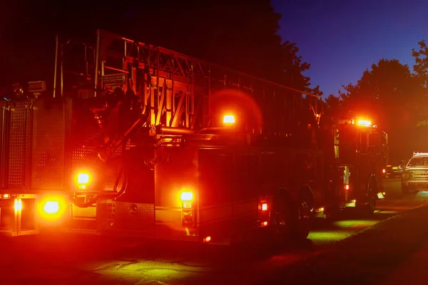 Fire truck with flashing red lights of a fire engine night time in dusk