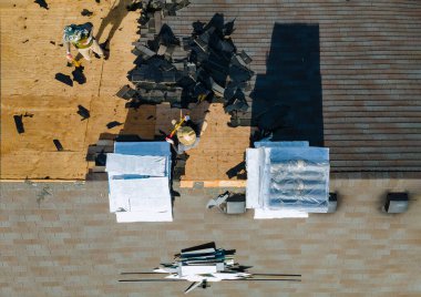 Yeni çatı kiremitleri üzerine inşaat işçisi. Ev yeni konut kiremitleri döşedi.