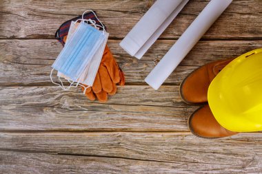 Endüstri işçisi koruyucu ve cerrahi maske, iş giysisi güvenlik botları deri eldivenler ofis koronavirüs salgınının planlarıyla çalışan mimarlara sarı başlık.,