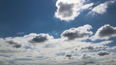 Yumuşak beyaz bulutların inanılmaz zaman atlaması güzel, kalın, kabarık bulutların arasında ilerlerken açık mavi gökyüzünde yavaşça.
