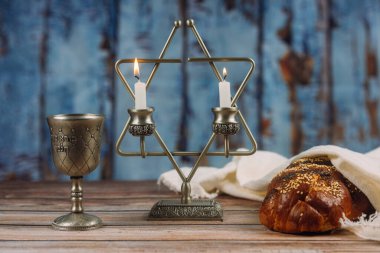 Shabbat Jewish holiday with challah bread on a candles and cup of wine. clipart